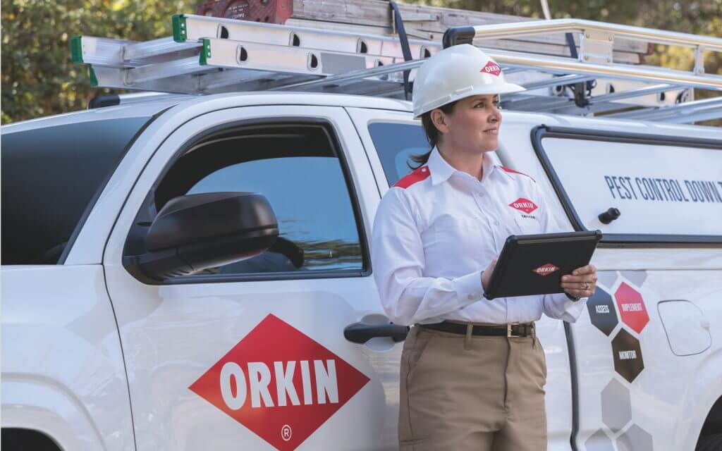 Technicienne d'Orkin Canada devant son camion